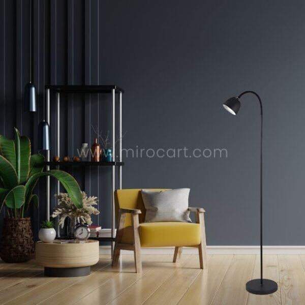Sleek black Modern FJORD Floor Lamp casting warm light in a stylish living room with a vibrant yellow armchair and decorative elements.