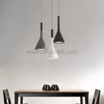 Three Nordic Cone Pendant Lamps in black, gray, and white hanging above a simple dining table with dark vases as centerpieces.