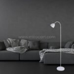 White Modern FJORD Floor Lamp adding sophistication to a contemporary living area with a sleek black sofa.