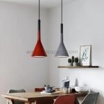 Two Nordic Cone Pendant Lamps in brique and gray suspended above a wooden dining table adorned with decorative items and framed artwork.