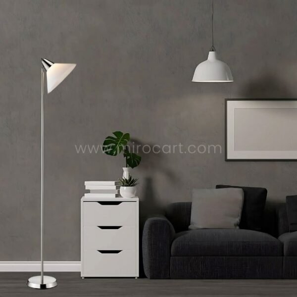Adesso Swivel Floor Lamp with a chrome pole and white shade, placed near a sofa and side table in a stylish living area.