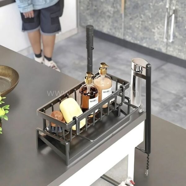 Stainless kitchen sink caddy with adjustable mounting arm mounted on a countertop.
