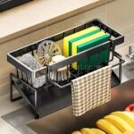 Stainless kitchen sink caddy with multiple compartments holding sponges and cleaning tools on a modern sink.
