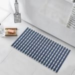 Blue textured non-slip bathroom mat placed on a tiled floor near a bathtub, soap dish, and showerhead.