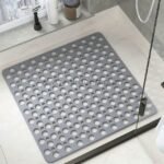 Gray non-slip massage bath mat placed on floor near sink, showing its use in high-traffic bathroom zones.