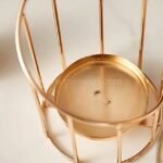 Bottom view showing engraved logo and weighted brass base of golden pillar candle holder.