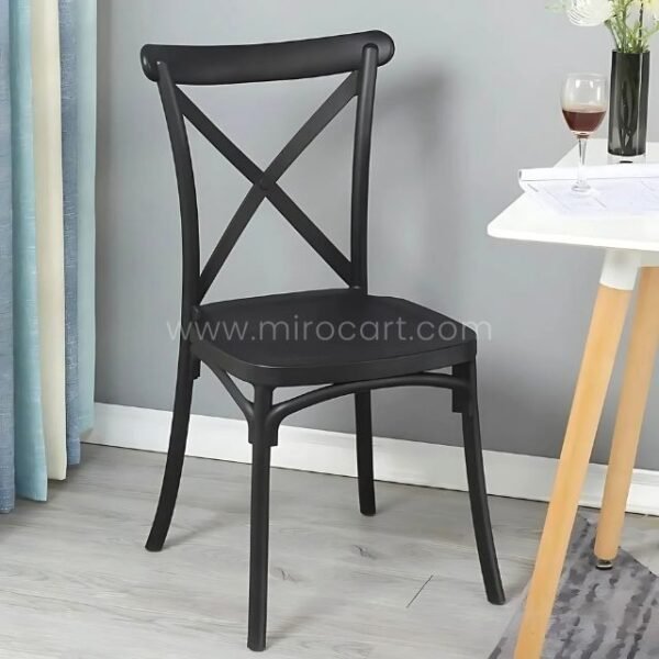 Black cross-back chair at a modern workspace.