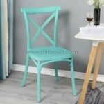Vibrant turquoise chair by a rustic wooden table.