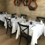 Black cross-back chairs in an elegant bistro arrangement.