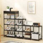 A fully assembled black shoe rack with multiple layers, neatly organized with shoes, baskets, and decor in a modern entryway.