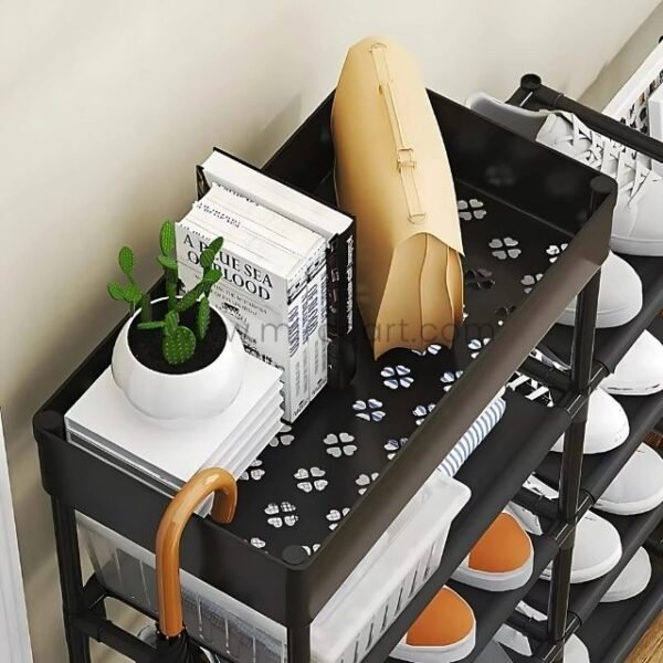 A close-up of the black shoe rack showing its versatility with books, decor, and accessories stored on the top shelf.