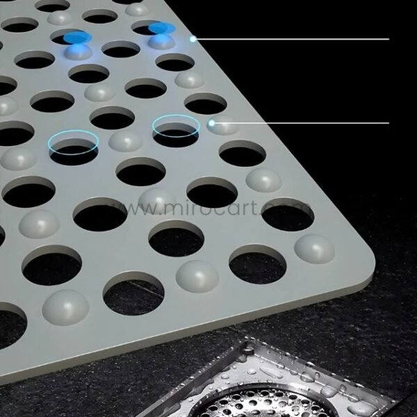 Close-up of a gray non-slip massage bath mat showing holes and suction cups.
