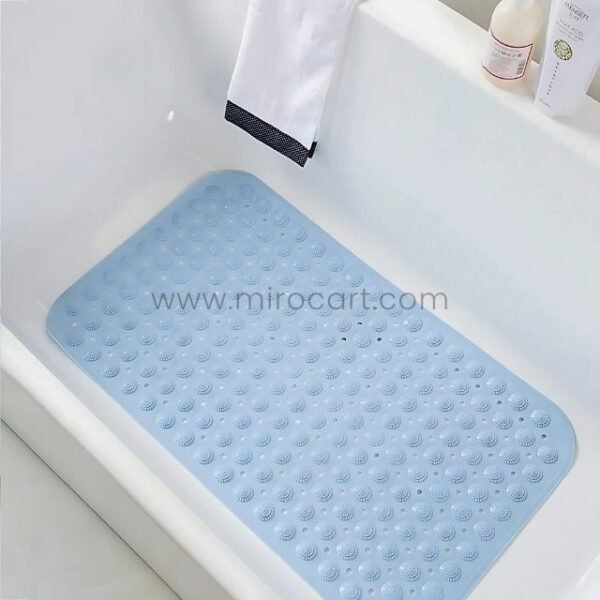 A light blue non-slip bathtub mat placed inside a white tub for added safety during bathing.