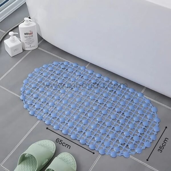 A blue non-slip shower mat with circular patterns, placed on a tiled floor near a bathtub, with dimensions labeled as 65 cm x 35 cm.