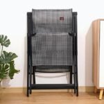 A premium zero-gravity lounge chair folded upright against a wall, showcasing its compact design and mesh fabric.