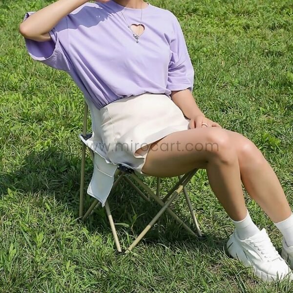 Woman relaxing in purple shirt on camping chair.