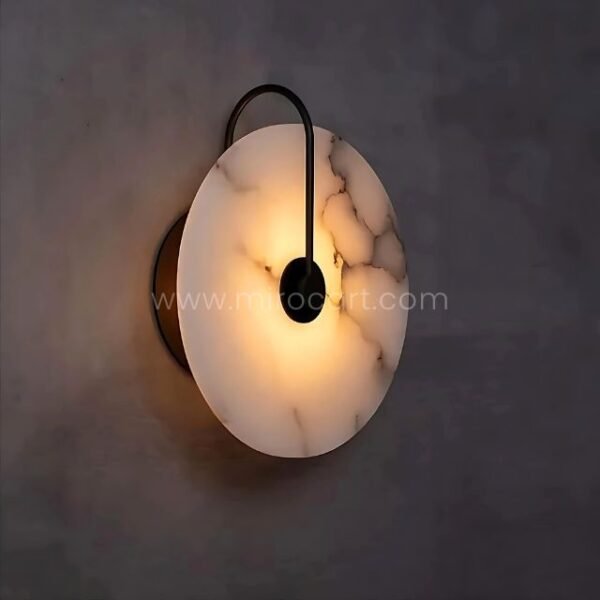 Black-framed Moonlit Alabaster Wall Light glowing warmly against a deep-toned wall.