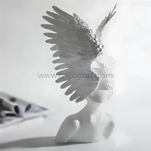 Celestial Winged Angel Sculpture glowing under soft, natural light, with shadows dancing across its detailed wings.