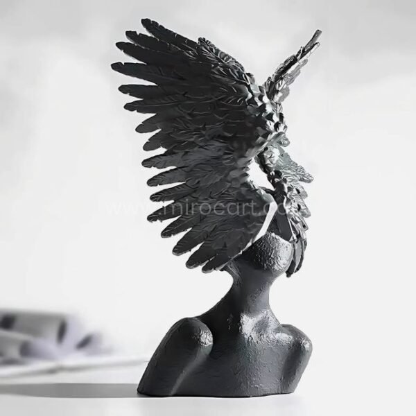 Close-up of black Celestial Winged Angel Sculpture, showing its dramatic texture and wing design.