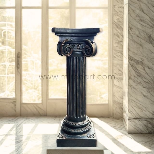 A sleek, dark-colored classical Roman pillar stands elegantly in a sunlit modern home with marble walls and large windows.