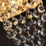 Sharp close-up of the Crystal Cascade Wall Light’s crystals and faceted gold hardware.