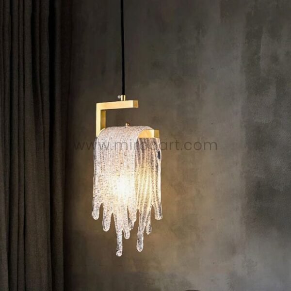 A modern Flowing Waterfall Pendant Light drips with cascading crystal strands, casting a hypnotic glow over a moody corner framed by dark curtains and textured walls.