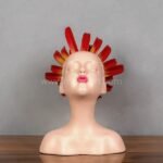 Angled look at the sculpture’s playful kissy face and flaming crown.