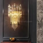 Crystal Cascade Wall Light casting a warm glow in a sleek, moody-modern interior with dark walls.