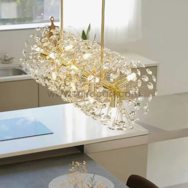 Gold bar chandelier with crystal branches sparkling above a minimalist kitchen island.