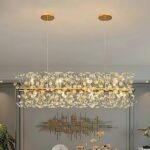 Luxury gold bar chandelier above a modern living room with artful wall decor.