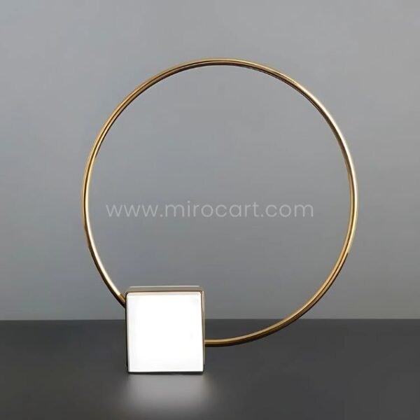 Minimalist Golden Ring Sculpture in a neutral black-and-white space.