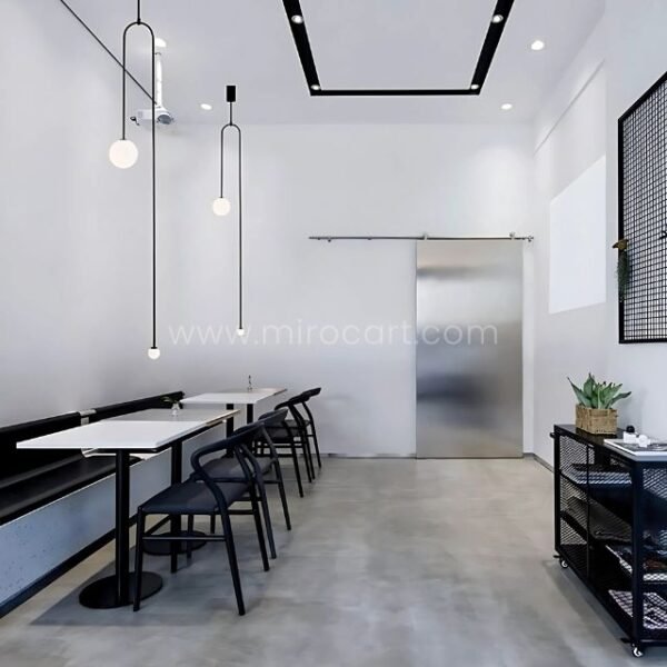 Black modern arc pendant lights above a minimalist dining table.
