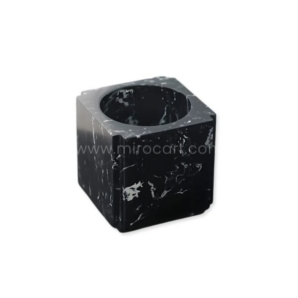 Clean shot of a modern black marble vase against a neutral background, showcasing its cube shape and central opening.