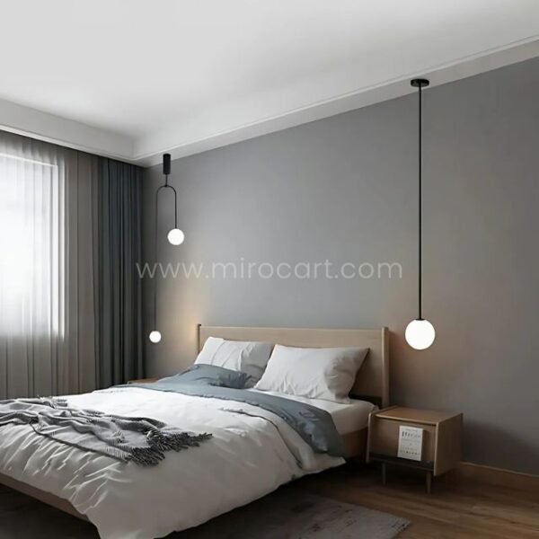 Single black modern arc pendant light in a minimalist bedroom setup.