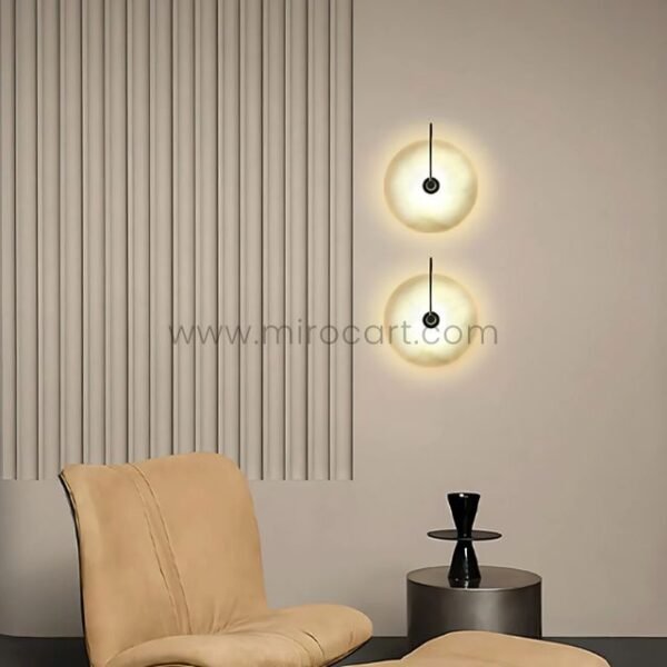 Pair of Moonlit Alabaster Wall Lights with black frames in a minimalist beige-toned living room.