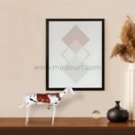 Shattered Ride sculpture displayed on a wooden console, framed by soft-toned decor and abstract art.