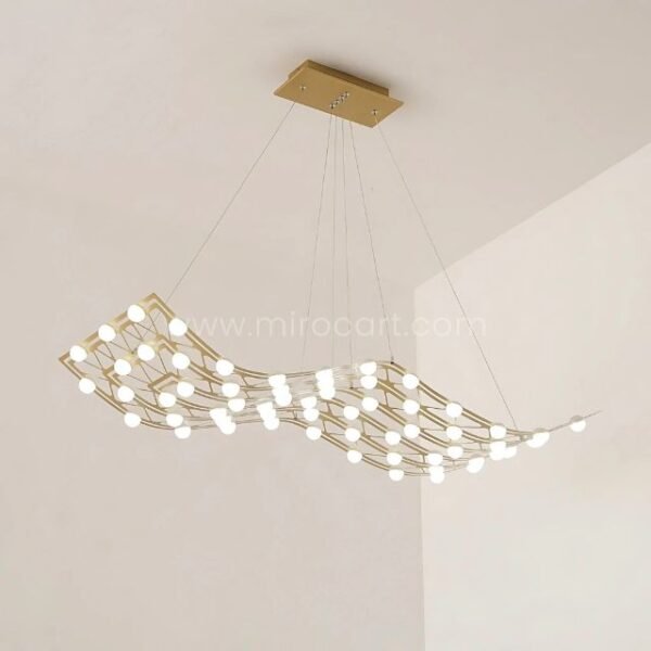 Serpentine flowing gold chandelier cascading in a bright, airy white room.