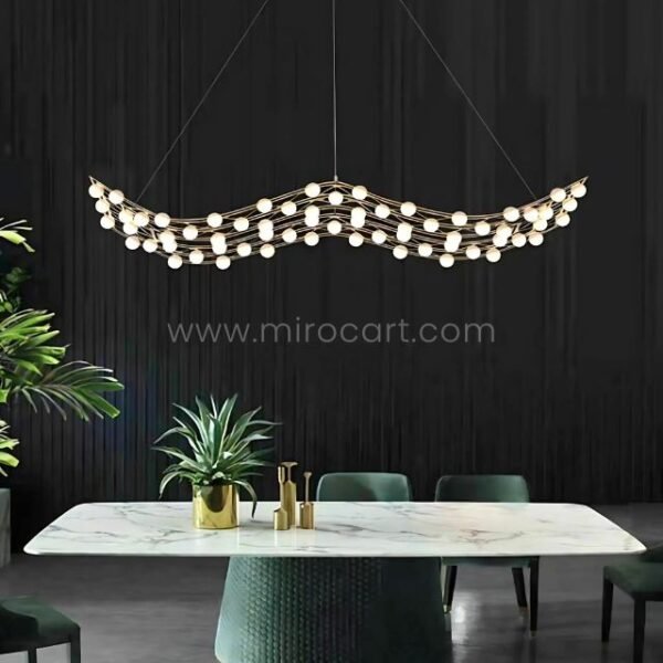 Dramatic dark walls meet a flowing gold chandelier, its wavy design popping against emerald-green accents.