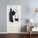 Over-the-door hook rack holding a jacket, cap, and bag in a stylish entryway.