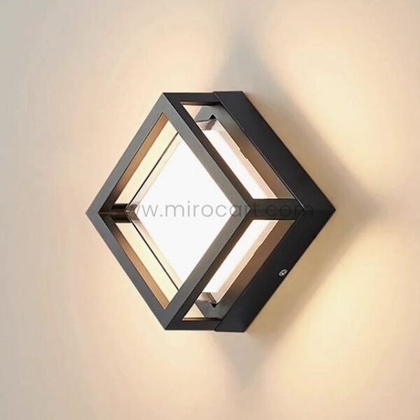 Sleek cube wall light emitting 3000K warm white glow on neutral wall.