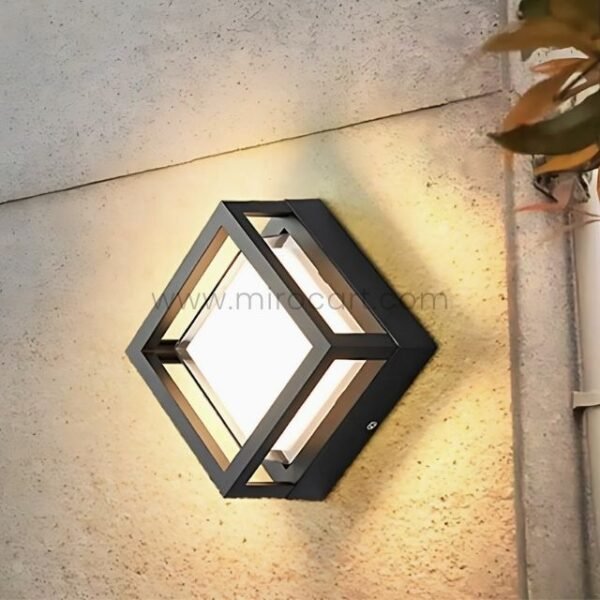 Sleek cube LED wall light on concrete with soft ambient lighting.