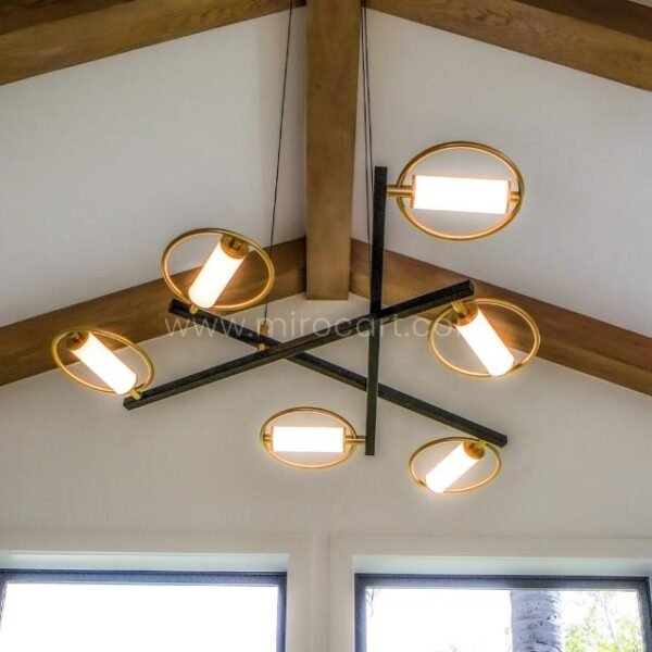 Modern Cross Pendant Chandelier hanging in an A-frame room with natural light and exposed wood.