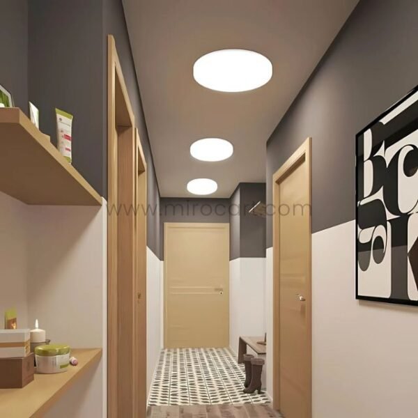 Sleek LED ceiling downlight illuminating a hallway with wood accents and modern decor.
